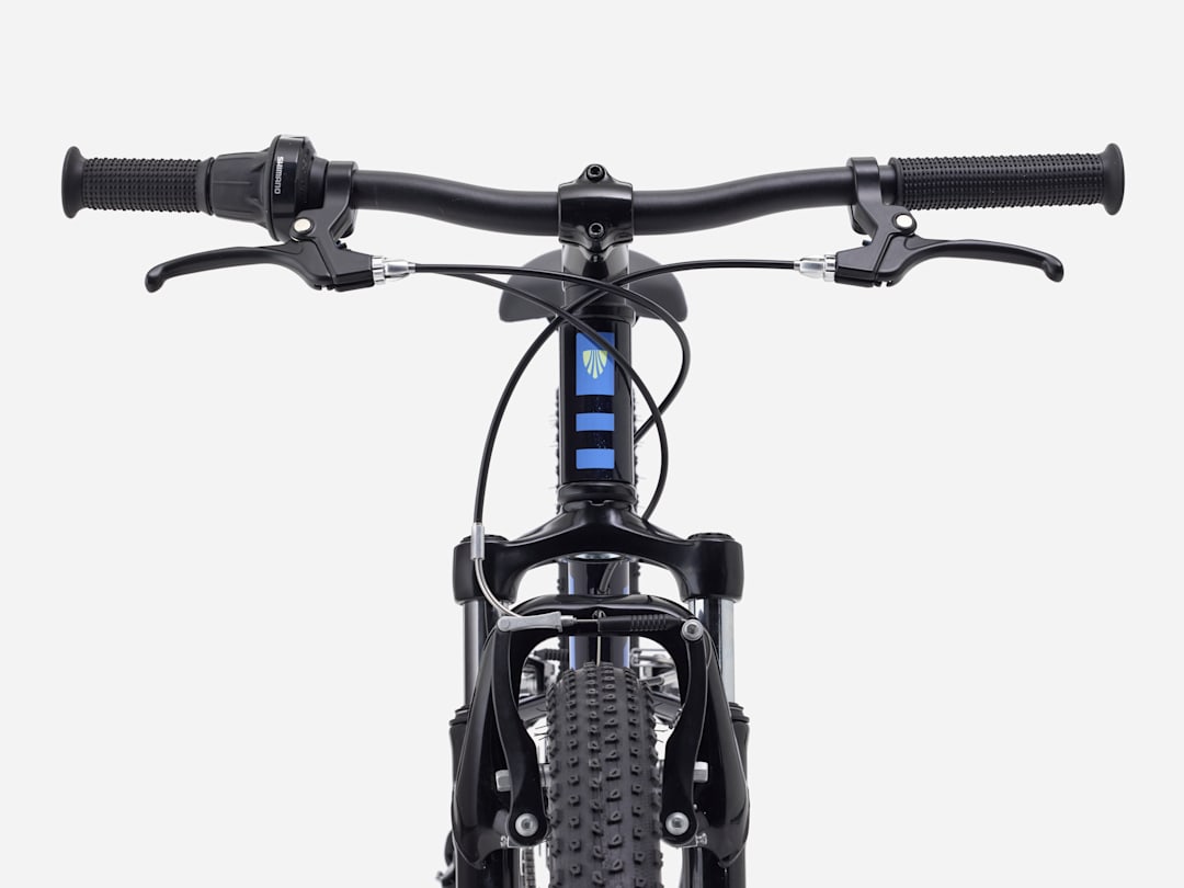 2027 Trek Precaliber 24" Suspension Kids Bike handlebars and controls from the front view.
