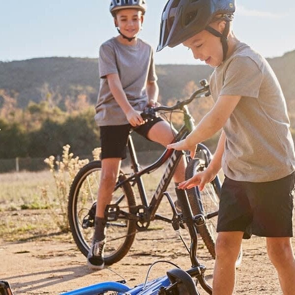 Two children with bicycles in a natural setting